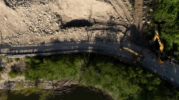 Mignano, İtalya - 22 Nisan 2025 Havadan çekilen ve Mignano Barajı 'nda engellenmiş SP21 Vernasca fotoğrafı, yol kenarında park halindeki kazıcılarla birlikte toprak kayması yaşıyor