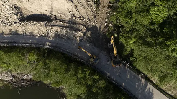 Mignano, İtalya - 22 Nisan 2025 Havadan çekilen ve Mignano Barajı 'nda engellenmiş SP21 Vernasca fotoğrafı, yol kenarında park halindeki kazıcılarla birlikte toprak kayması yaşıyor