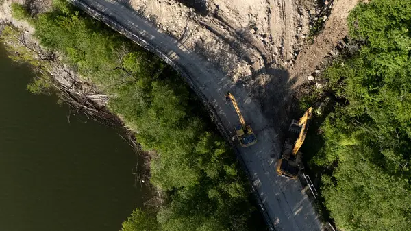Mignano, İtalya - 22 Nisan 2025 Havadan çekilen ve Mignano Barajı 'nda engellenmiş SP21 Vernasca fotoğrafı, yol kenarında park halindeki kazıcılarla birlikte toprak kayması yaşıyor
