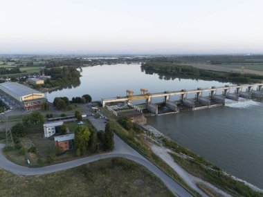 Carlo Bobbio 'nun Isola Serafini' deki havadan Piacenza ve Cremona arasındaki Po Nehri 'ndeki barajının günbatımında çekilen görüntüsü balık yolu projesinin akıntıya karşı mersin balığı göçüne olanak sağladığını gösteriyor..