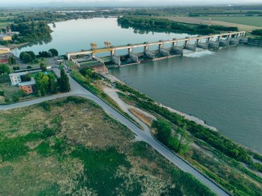 Carlo Bobbio 'nun Isola Serafini' deki havadan Piacenza ve Cremona arasındaki Po Nehri 'ndeki barajının günbatımında çekilen görüntüsü balık yolu projesinin akıntıya karşı mersin balığı göçüne olanak sağladığını gösteriyor..