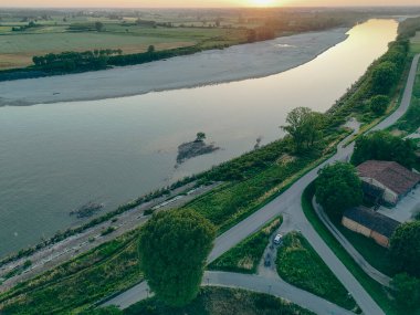 Baharda gün batımında yakalanan bu drone çekimi, Po Nehri 'ndeki Isola Serafini barajını gösteriyor. Orada yeni bir balık geçidi mersin balığı ve yılan balığı yaşam alanlarını onlarca yıl boyunca nehrin yukarısına doğru bloke ettikten sonra yeniden birleştiriyor..