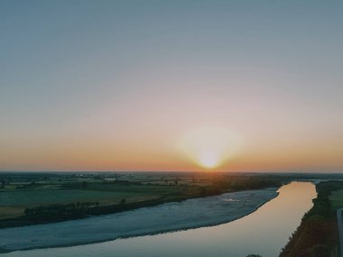 Carlo Bobbio 'nun Isola Serafini' deki havadan Piacenza ve Cremona arasındaki Po Nehri 'ndeki barajının günbatımında çekilen görüntüsü balık yolu projesinin akıntıya karşı mersin balığı göçüne olanak sağladığını gösteriyor..