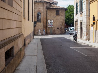 Cremona, İtalya 11 Haziran 2025 Avrupa caddesinden geçen yaşlı rahibeler, parlak güneş ışığı altında yakınlardan geçen bisikletçiler, İtalya 'da geleneksel şehir manzarası