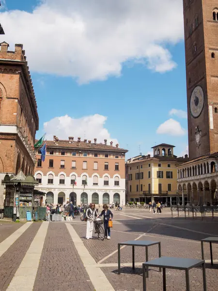 Cremona, İtalya 11 Haziran 2025 iki kadın güneşli bir bahar gününde İtalya 'nın Cremona kentindeki Piazza del Comune' da yürüyorlar.