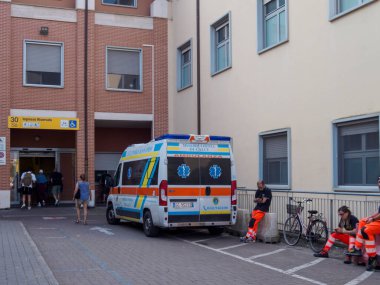 Cisanello, PI, İtalya - Hastane girişinde 13 Haziran 2025 Ambulans Sağlık Hizmetleri acil servis binasının önünde dinlenen acil servise giren insanlar
