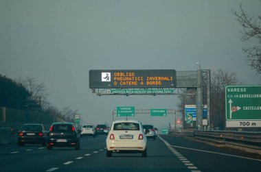 Milan, İtalya - 27 Aralık 2023 Milano otoyolunda sıradan bir gün İtalyan otoyolu boyunca asfalt yolculuğu, zaman trafiği ve altyapısını hızlandıran manzaralı bir sürüş