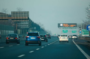 Milan, İtalya - 27 Aralık 2023 'te İtalya' nın Milano otoyolunda sabah trafiği kış mevsimi boyunca gündüz saatlerinde birçok arabanın bulunduğu bir otoyol gösteriyor