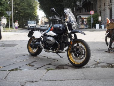 Cremona, İtalya 11 Haziran 2025 BMW R 99 Urban GS motosikleti, siyah beyaz üniforma, altın jantlar ve ek far parlatıcısı, şehir merkezinde bir kaldırım taşı caddesinde duruyor