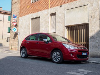 Cremona, İtalya 11 Haziran 2025 Red Citroen C3 ikinci nesil - 2009 - tuğla bir duvarın yakınındaki bir yerleşim yerine park edilmiş yol işaretleri hız limitini ve park yasağını göstermektedir.