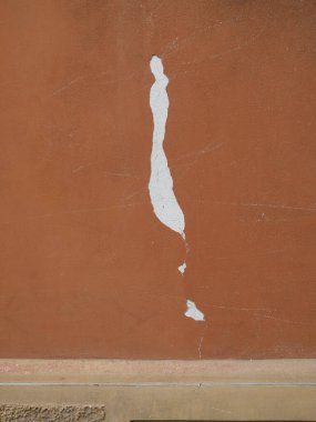 Turuncu bir duvardaki hasarlı boyayı kapatmak, alttaki beyaz alçıyı ortaya çıkarmak, bozulma ve Cremona, Lombardy, İtalya 'da restorasyon ihtiyacı