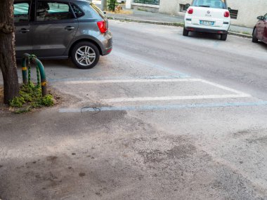 Bologna, İtalya 3 Temmuz 2025 Volkswagen Polo ve Fiat Fikri şehir bağlamında beyaz ve mavi çizgilerle sınırlanmış bir park alanına doğru park ediyorlar.