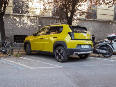 Bolonya, İtalya 3 Temmuz 2025 Modern Limon Sarı Fiat Grande Panda Elektriği bir şehir sokağına park edilmiş, kompakt SUV tasarımı ve spor çekiciliği ile bir bisiklet ve scooter 'ın yanında sergilenmektedir.