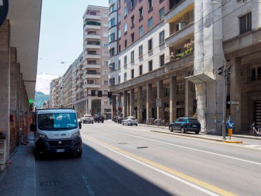 Bologna, İtalya 3 Temmuz 2025 Bologna caddesinde inşaat alanının yanına park edilmiş beyaz minibüs, güneşli su sırasında geçen araçlar ve mimari arkaplanlarla çevrili şehir manzarası