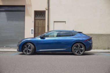 Cremona, İtalya - 1 Nisan 2025 Modern elektrikli araba lüks tasarımı ve şarj portunu sergileyerek sürdürülebilir şehir ulaşımını sembolize ediyor