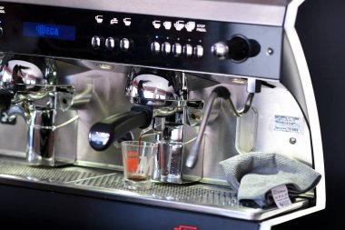 Cremona, İtalya - 19 Temmuz 2025 Profesyonel Espresso Makinesi Parlak Krom yüzeyli ve Temizlenmeye Hazır Yumuşak Kumaşlı Modern Kahve Dükkanında Lezzetli Sıcak Bir İçecek Hazırlıyor