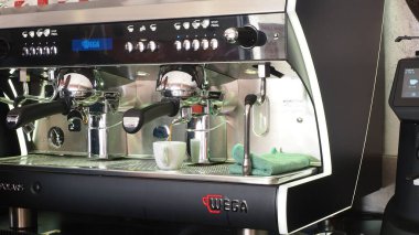 Cremona, İtalya - 26 Temmuz 2025 Modern bir kafe ortamında kaliteli kahve makinesi kullanan yetenekli bir baristanın yakın çekimi.