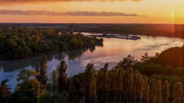 İtalya 'nın Cremona kentindeki canlı bir günbatımında Po Nehri' ne yayılan Demir Köprü 'yü, bir yol ve demiryolu viyaoluğunu ele geçiren İHA, çevresindeki yemyeşil araziyi ve sakin suları gözler önüne seriyor.