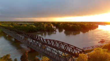 Demir Köprü, yol ve demiryolu viyadük Cremona, Lombardy, İtalya 'da Po Nehri' ni geçiyor, gün batımında iki bankayı metal kemerler ve tuğla sütunlarla birbirine bağlıyor.