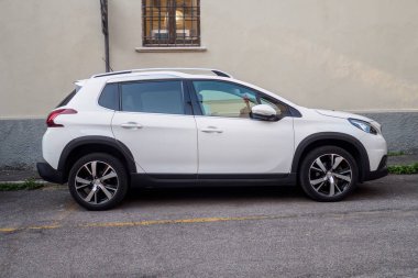 Cremona, İtalya 6 Ağustos 2025 Modern beyaz Peugeot 2008 SUV bir binanın yakınındaki bir caddenin kenarına park edilmiş, gösterişli tasarımı ve kentsel pratikliği sergilenmektedir.