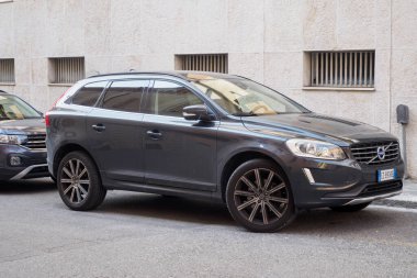 Cremona, İtalya 6 Ağustos 2025 Volvo XC60 D4 Kinetik park yeri bej duvarın yanında, demir parmaklıklı pencereler ön ve yan açıdan parlak güneş ışığı altında parlıyor.