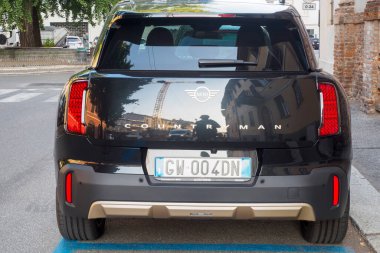 Cremona, İtalya 6 Ağustos 2025 Marka ve plaka gösteren siyah Mini Vatandaş, belirlenmiş bir şehir otoparkındaki kentsel çevreyi yansıtıyor.