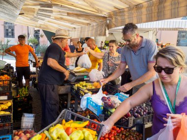 Cremona, İtalya 6 Ağustos 2025 Cremona, Lombardy, İtalya 'da canlı bir açık hava pazarından taze ürünler alan insanlar olgun seçimlerin keyfini çıkarıyorlar.