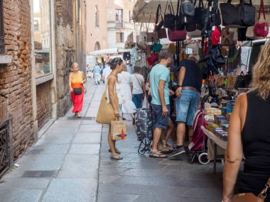 Cremona, İtalya 6 Ağustos 2025 'te, turistler güneşli bir yaz gününde İtalya' nın Cremona kentindeki kalabalık bir sokak pazarında çanta ve hediyelik eşya alışverişi yapıyorlar.