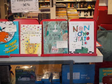 Cremona, İtalya 6 Ağustos 2025 Renkli çocuk kitapları bir kitapçının vitrininde duruyor, Cremona, Lombardy, İtalya 'daki genç okuyucular için büyüleyici hikayeler ve çizimler sunuyorlar.