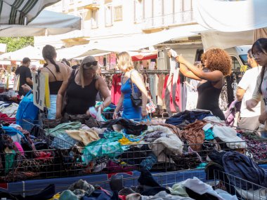 Cremona, İtalya 6 Ağustos 2025. Kadınlar, İtalya 'nın Cremona kentindeki bir markette renkli kıyafetleri karıştırarak alışveriş ve açık hava aktiviteleriyle dolu güneşli bir yaz gününün tadını çıkarıyorlar.