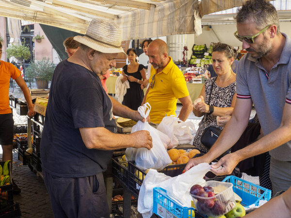 Cremona, Italy August 6th 2025 People buying fresh produce from local vendors at a lively outdoor market in Cremona, Lombardy, Italy, enjoying ripe selections