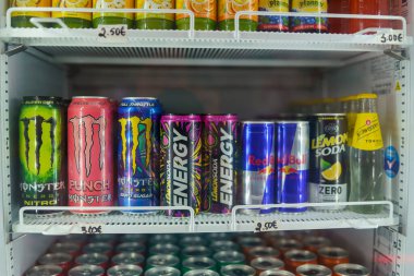 Cremona, İtalya 25 Temmuz 2025 Konserve ve şişe Canavar Enerjisi. Kızıl Boğa. Limonlu soda. Ve Schweppes Tonica bir süpermarkette soğutulmuş vitrinde raflara güzelce yerleştirilmiş.