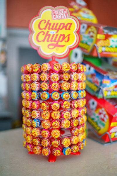 Кремона, Италия 25 июля 2025 года Разноцветные леденцы Chupa Chups, размещенные на вращающемся стенде, подчеркивают разнообразие вкусов