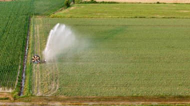 İtalya 'daki geniş yeşil soya tarlaları, parlak bahar döneminde dönen büyük bir fıskiye sistemiyle sulanır ve ferahlatıcı bir yağmur yağar. Po Vadisi tarım arazisinde yaygın bir manzara.