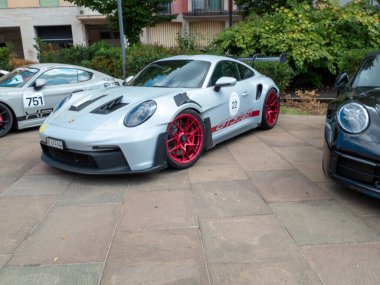 Cremona, İtalya 22 Ağustos 2025 Açık gri Porsche 991 GT3 RS kentsel bir ortamda kaldırıma park edilmiş kırmızı jantlarla spor tasarımı ve yüksek performanslı özelliklerini sergilemektedir.