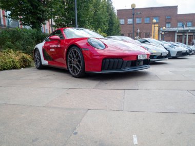 Cremona, İtalya 22 Ağustos 2025 Parlak kırmızı Porsche 911. İtalya 'da bulunan bir motor sporları yarış pisti olan, Porsche Experience Center Franciacorta' nın yakınındaki kaldırımda park etmiş özel bir üniforması var.