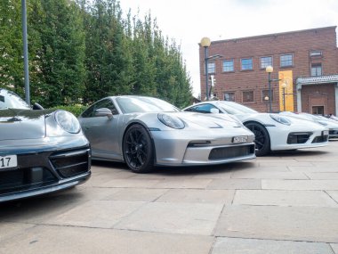 Cremona, İtalya 22 Ağustos 2025 siyah bir Porsche 911 'in ön görüntüsü gümüş renkli bir Porsche' nin yanında şehir ortamında, lüks ve otomotiv tasarımı sergileniyor.