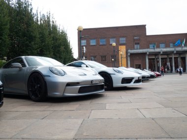 Cremona, İtalya 22 Ağustos 2025 Gösterişli Porsche 911 araçları tarihi mimarinin yanında parlayarak, İtalya 'nın Cremona kentinde düzenlenen Stradivari Festivali sırasında otomotiv zarafetini ön plana çıkardılar.