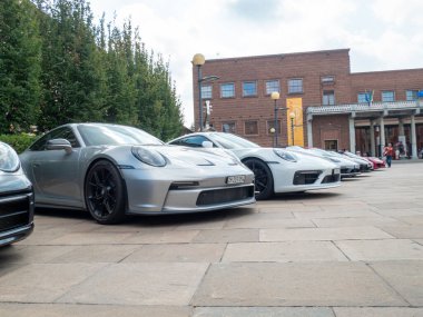 Cremona, İtalya 22 Ağustos 2025 Gösterişli Porsche 911 araçları tarihi mimarinin yanında parlayarak, İtalya 'nın Cremona kentinde düzenlenen Stradivari Festivali sırasında otomotiv zarafetini ön plana çıkardılar.