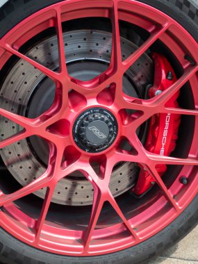 Cremona, İtalya 22 Ağustos 2025 Kırmızı magnezyum alaşımlı tekerleği kapatın, delinmiş bir fren diski ve kırmızı fren kalibresini gösterin, modern bir spor arabanın performansını ve stilini vurgulayın