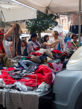 Cremona, Italya- 23 Ağustos 2025 Cremona Lombardy İtalya 'da Açık Market Dükkanı. Çeşitli İnsanlar Renkli Giysiler ve Tekstil Tarama Yapıyor Güneşli Bir Gün Yerel Ticaret Sahnesi