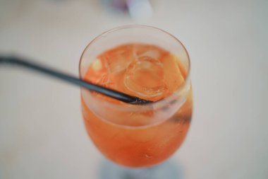 Bir bardak aperol spreyli kokteyl. İçi buz dolu. Taze portakal dilimleriyle süslenmiş.