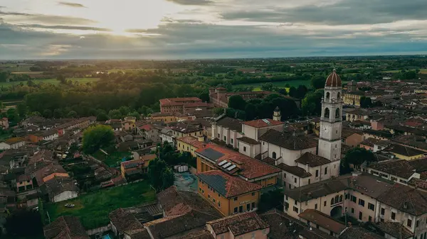 Pontevico 'nun sakin hava manzarası. Altın bir günbatımında Brescia Lombardy' nin büyüleyici bir İtalyan kasabası. Tarihi çatılar ve seçkin bir kilise kulesi üzerine sıcak bir parıltı saçıyor.