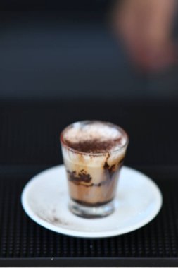 Cremona, İtalya - 21 Temmuz 2025 Kremalı ve Çikolata tozlu Küçük Lezzetli Kahve Bir Bardakta En İyi Servisli