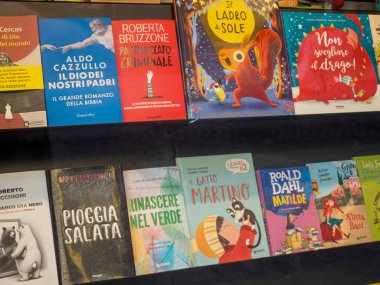 Milan, İtalya 14 Ağustos 2025 ilgi çekici başlıklı renkli kitaplar raflarda düzenlenerek Milano 'daki bir kitapçıda potansiyel okuyucular için davetkar bir sergi oluşturuldu.