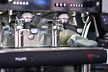 Cremona, İtalya - 19 Temmuz 2025 Barista Lombardiya İtalya 'da Yüksek Kaliteli Fasulyelerin Yumuşak Operasyonu ve Lezzetli Aromasını vurgulayan Profesyonel Kahve Makinesiyle Zengin Espresso İçkileri Hazırlıyor