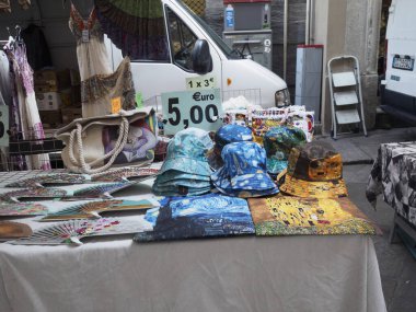 Cremona, İtalya - Lombardy İtalya 'da 6 Ağustos 2025 Vibrant sokak tezgahı güneşli bir günde turistlere ve yerel halka satılık renkli el yapımı şapka ve aksesuarlar sergiliyor