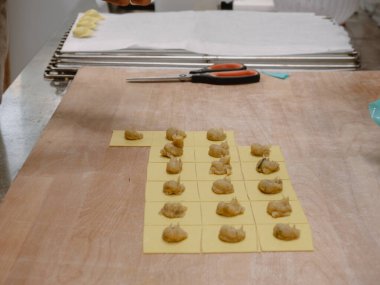 Yetenekli zanaatkar geleneksel İtalyan Tortelli 'yi profesyonel bir mutfakta elle hazırlıyor. Makarna yapma sanatına odaklanıyor.