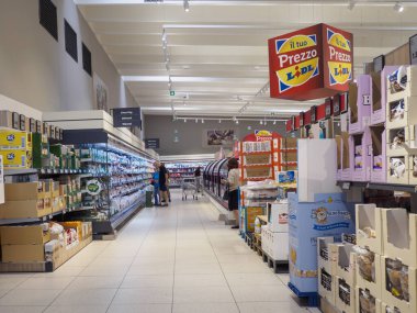 Cremona, İtalya - 31 Ağustos 2025 Renkli ürünler ve müşterilerle dolu modern indirimli bir süpermarket koridorunda Avrupa 'nın tipik bir marketinde raflara göz atıyorlar.