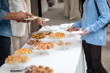 Elegant gathering of friends and family enjoying a delightful buffet selection of delicious prepared foods at a private event celebration.